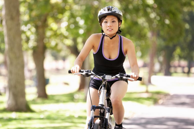 Woman Cycling Through Park